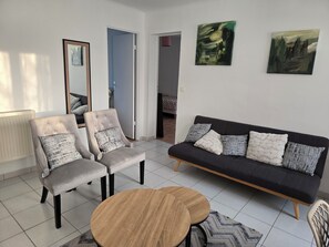 A modern living room with a sofa, two armchairs, a coffee table, and artwork on the walls. - Sejour eau vive, 3 bedrooms Near metro and créteil village (Créteil)