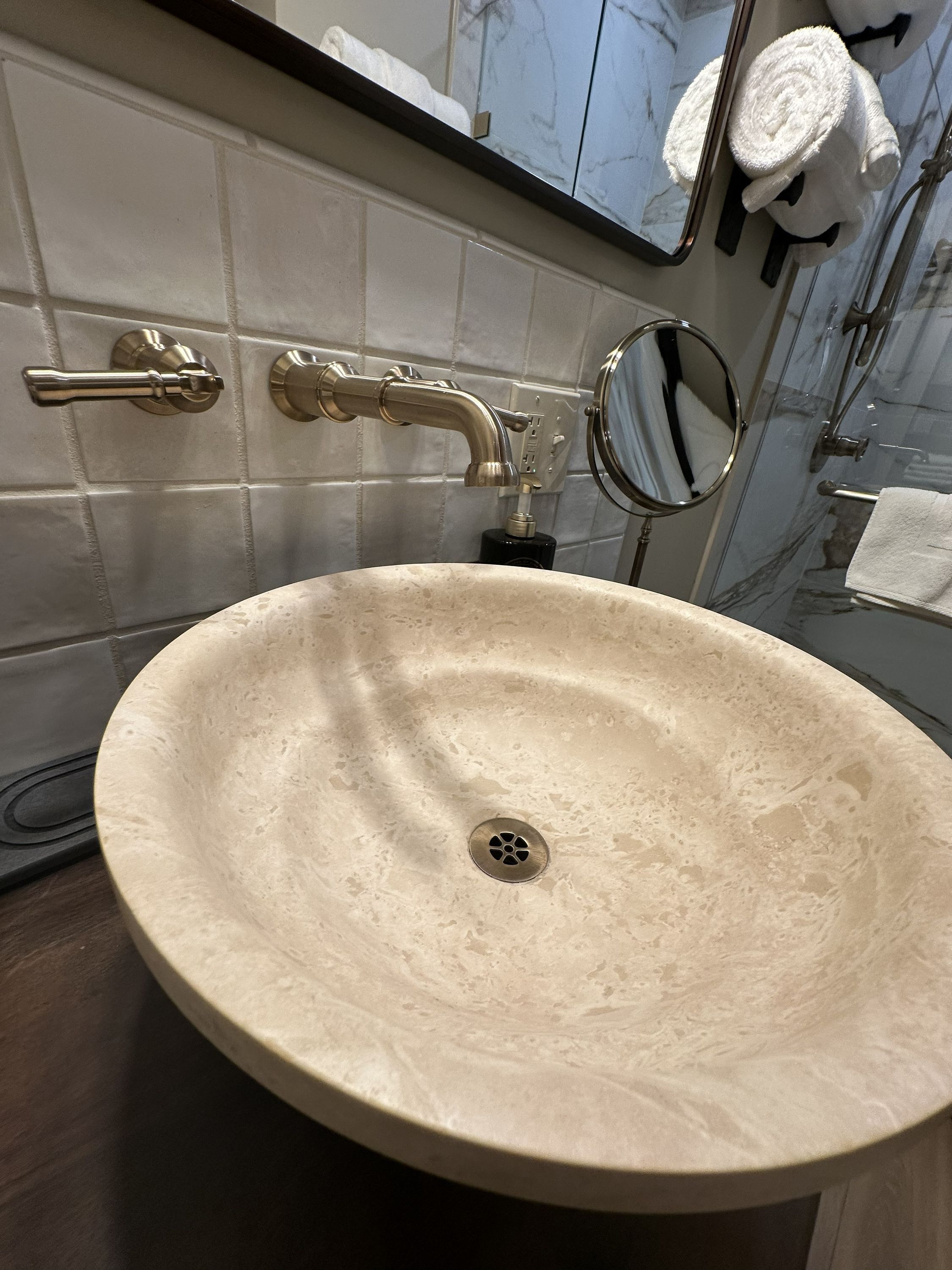 Un baño con un lavabo beige, un espejo y un perchero para toallas.