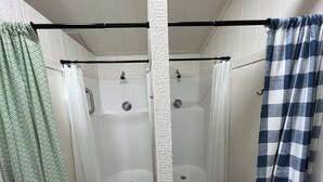 Een badkamer met een douche, een toilet en een houten kruk.
