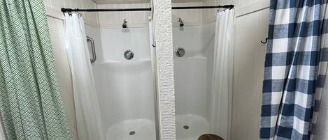 A bathroom with a shower, a toilet, and a wooden stool.