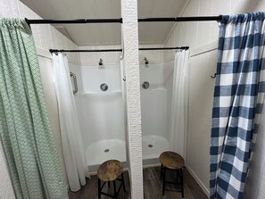 Une salle de bain avec une douche, des toilettes et un tabouret en bois.