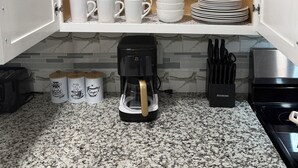 A kitchen with a coffee maker, cups, and plates on shelves. - Beautiful Luxury Retreat in Downtown Houston minutes to NRG/UT/Med Ctr/Zoo/ UH (Houston)