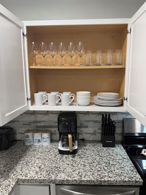 A kitchen with a coffee maker, cups, and plates on shelves. - Beautiful Luxury Retreat in Downtown Houston minutes to NRG/UT/Med Ctr/Zoo/ UH (Houston)