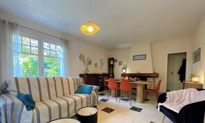 Ein Wohnzimmer mit einer Couch, einem Esstisch, Stühlen und einem Kamin.