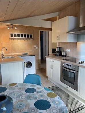 A compact kitchen with a washing machine, a stove, and a sink. - Les Oyats - ANDERNOS-LES-BAINS (ANDERNOS-LES-BAINS)