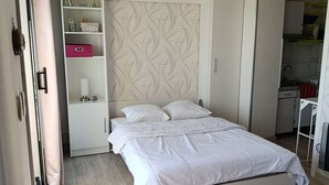 Une chambre à coucher avec un lit, une armoire, un bureau et une chaise.