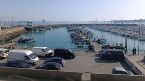 Un port de plaisance avec des bateaux amarrés, une jetée et des véhicules garés.