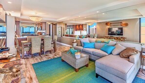 Ein modernes Wohnzimmer mit Sofa, Couchtisch und Essbereich.