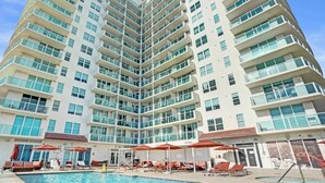 A high-rise hotel with a swimming pool and sun loungers. - 2BR Suite at The Arya | Coconut Grove (Miami)