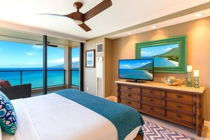 Ein Schlafzimmer mit einem großen Bett, einem Fernseher, einer Kommode und Meerblick.