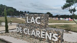 A sign with 'LAC DE CLAREN'S' written on it, surrounded by gravel and small rocks.