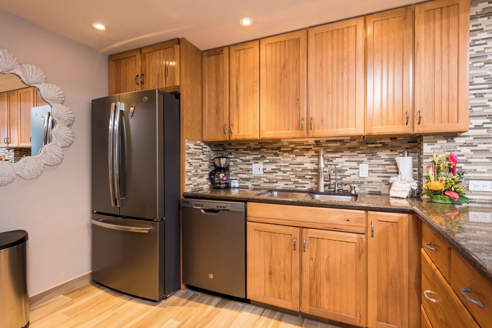 Une cuisine moderne avec des meubles en bois, des appareils électroménagers en acier inoxydable et un dosseret carrelé.