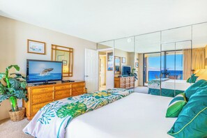 A bedroom with a bed, television, dresser, and a view of the ocean. - Mahana Villas | Oceanfront 7 BR Sleeps 21 | Car Incl. w/ 6+ Nights | MAH ML-3890 by KBM (Lahaina)