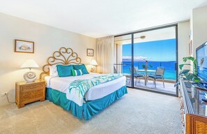 Ein Hotelzimmer mit Bett, Fernseher, Balkon mit Meerblick und Essbereich.