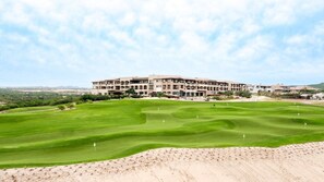 Un terrain de golf avec un grand bâtiment en arrière-plan.