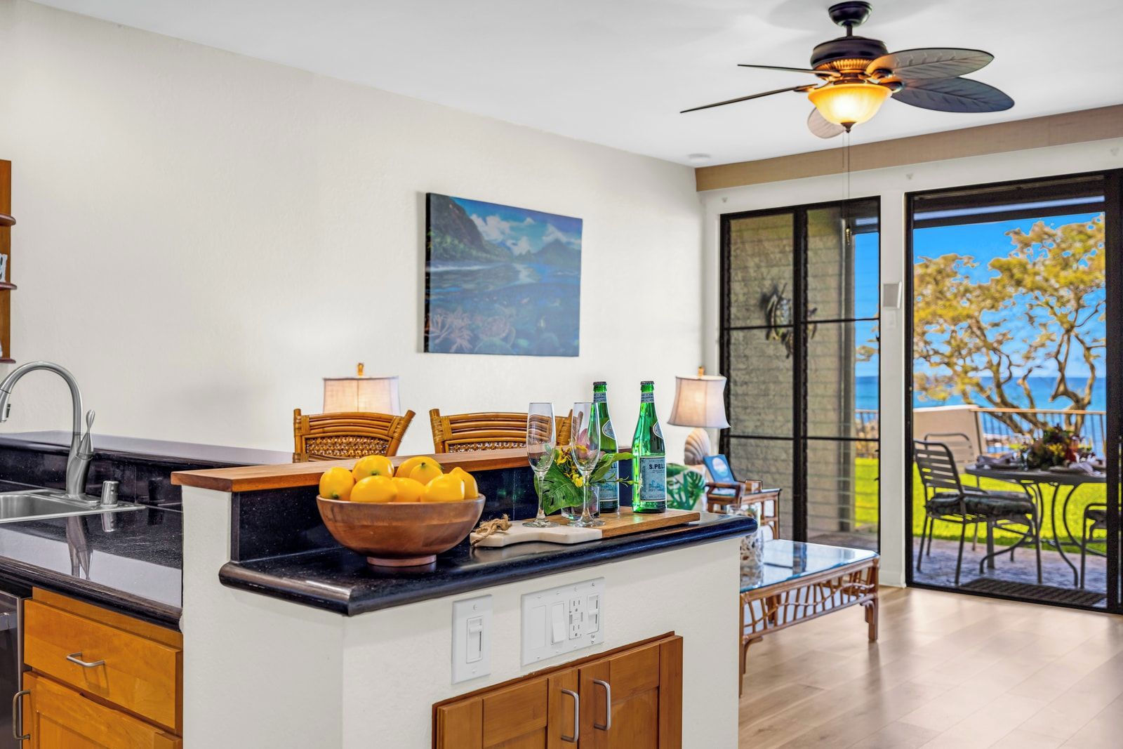 Une cuisine moderne avec un coin repas, un ventilateur de plafond et une vue sur l’extérieur.
