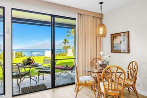 Ein Zimmer mit Glastür und Balkon, der Blick auf das Meer und Palmen bietet.
