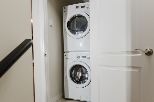 A laundry room with two stacked front-loading washing machines.