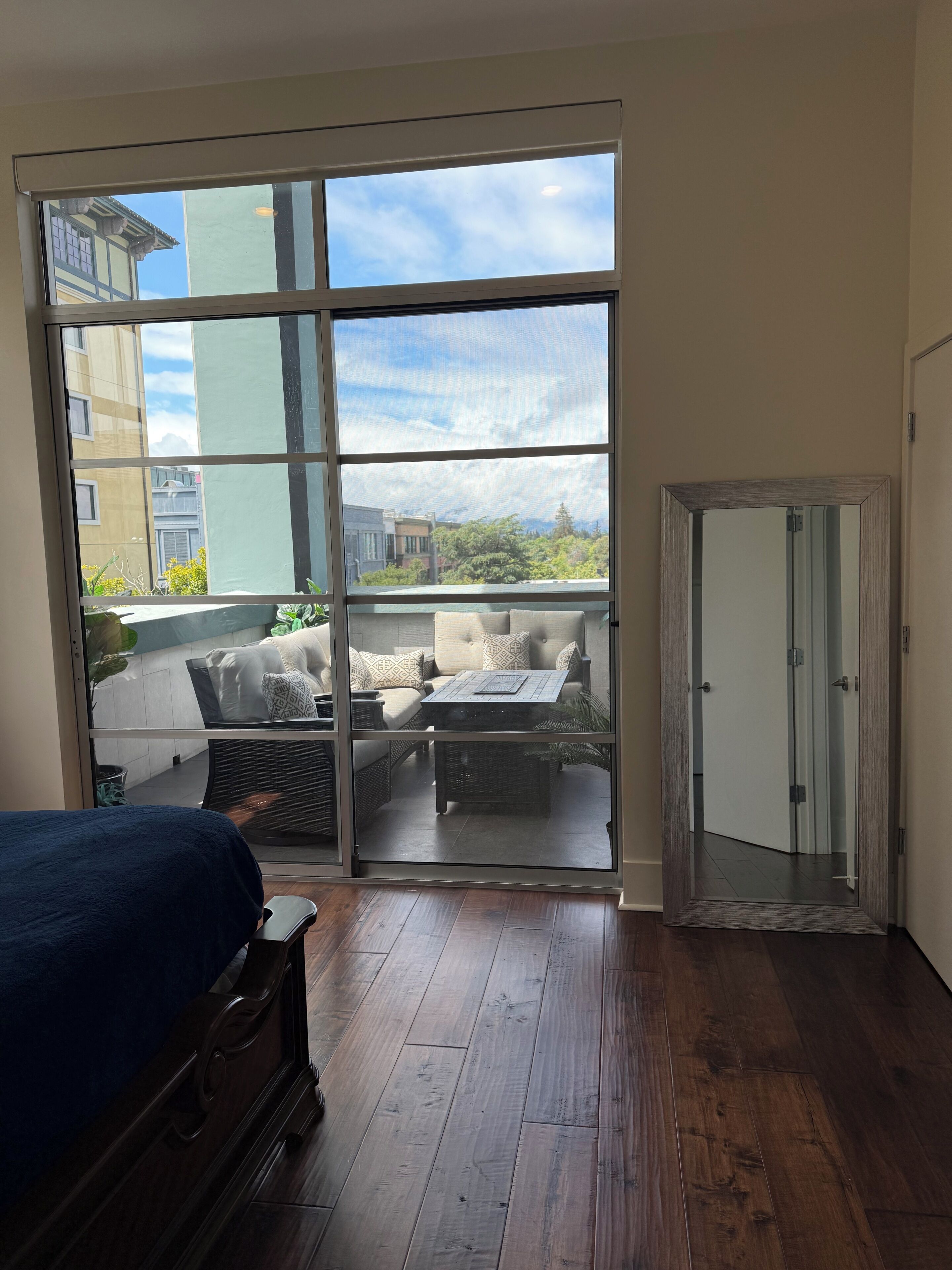 A room with a large sliding glass door leading to an outdoor patio with furniture.