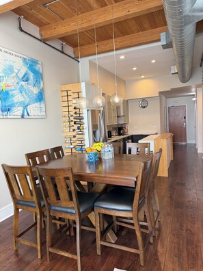 A dining area with a wooden table, chairs, and a fruit bowl.