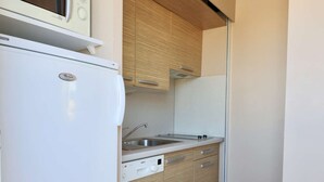 A compact kitchen with a refrigerator, microwave, and sink. - Le Jardin d'Eden 211 - Suite Junior Premium - 2 people (AGDE)