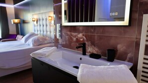 Un baño moderno con un espejo grande, una bañera y un tocador con lavabo.