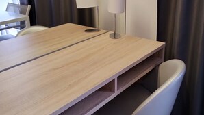 A wooden table with two lamps, a chair, and a view of the outside through a window. - Le Jardin d'Eden 113 - Suite Junior Premium - 2 people (AGDE)
