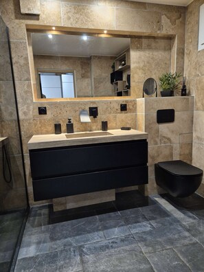 A modern bathroom with a large mirror, a vanity with a black sink, and a black toilet. - Le Jardin d'Eden - Suite Junior Luxe 139 with large terrace - 2 people (AGDE)
