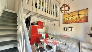 A modern interior with a staircase, dining area, and artwork. - CAP D'AGDE - MONT ST MARTIN // Réf 0314 (CAP D'AGDE)