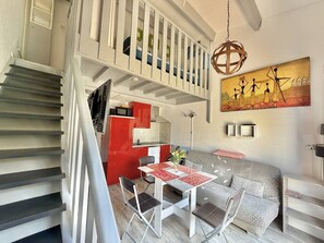 A modern interior with a staircase, dining area, and artwork. - CAP D'AGDE - MONT ST MARTIN // Réf 0314 (CAP D'AGDE)