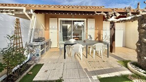 A patio with a table and chairs, a ladder, and a door leading to an interior space. - CAP D'AGDE - Richelieu // Réf 0309 (CAP D'AGDE)