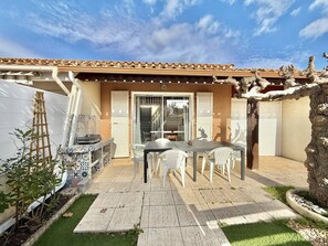 A patio with a table and chairs, a ladder, and a door leading to an interior space. - CAP D'AGDE - Richelieu // Réf 0309 (CAP D'AGDE)