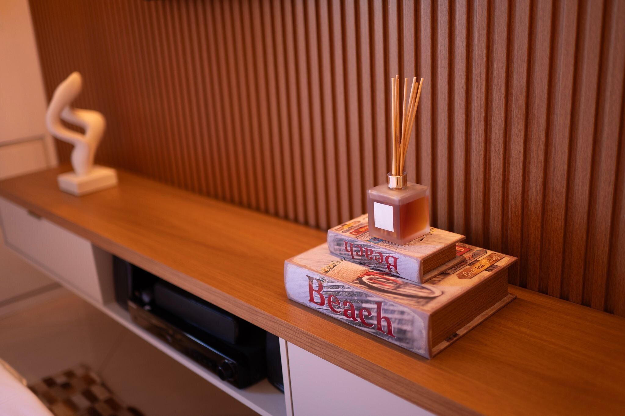 A wooden shelf with a decorative item and a box labeled 'Beach.'