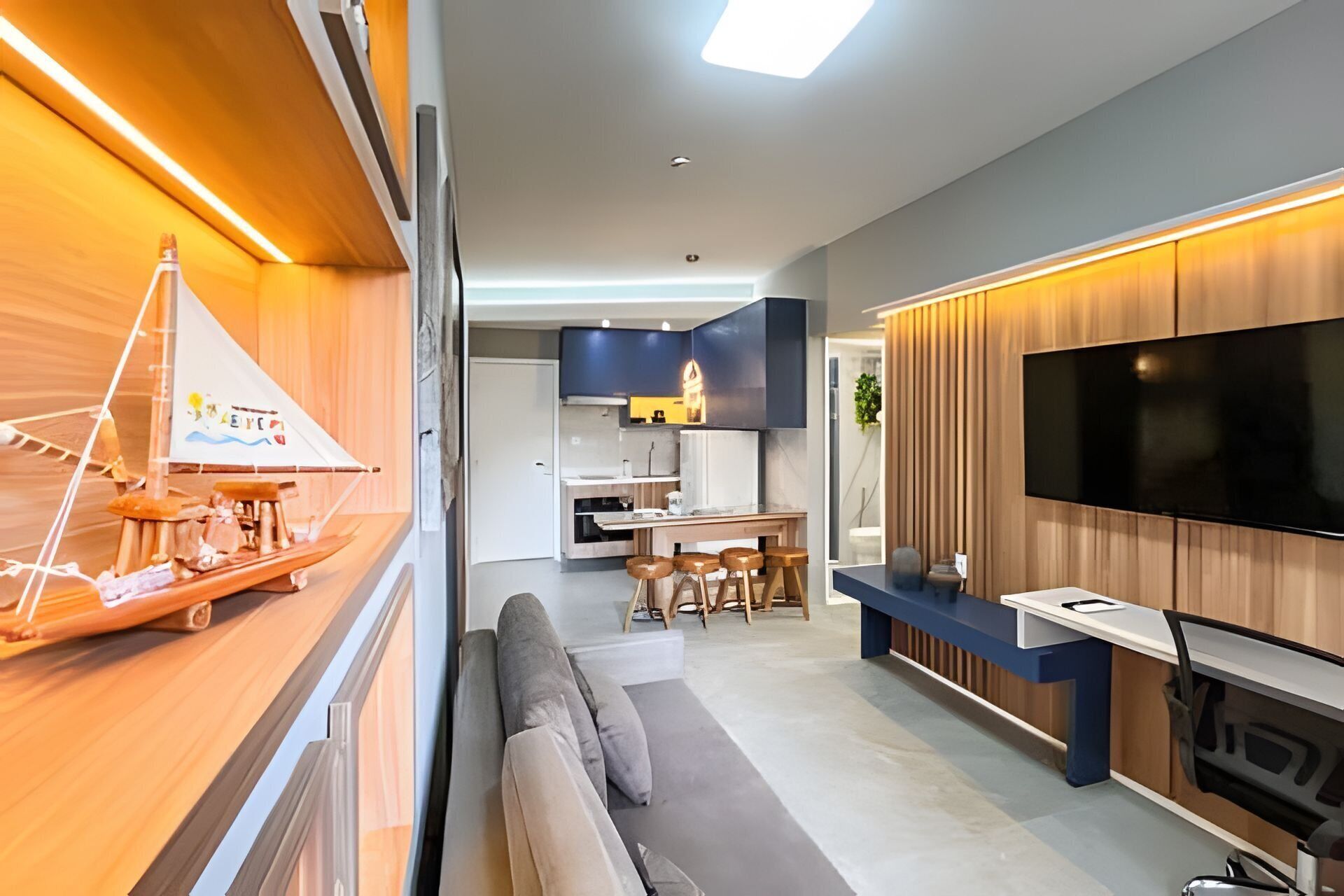 Un salon moderne avec un mur d’accent en bois, un téléviseur à écran plat, un banc intégré et une petite table.
