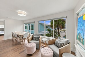 A spacious room with a dining area, seating, and a view of the outdoors. - BG Beach Club 3E | 3BR/2BA Boca Grande Condo (Boca Grande)
