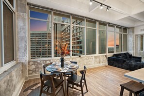 A modern interior with a dining area, large windows, and a city view. - Skyline Atlanta Stay | King Suites + Pool (Atlanta)