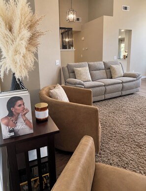 A living room with a sofa, a coffee table, and a vase with dried plants. - Beautiful Home in Moreno Valley (Moreno Valley)
