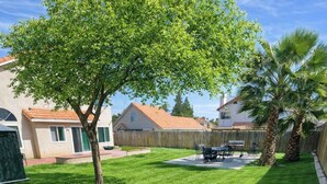 A well-maintained backyard with a lawn, a wooden fence, and a patio area. - Beautiful Home in Moreno Valley (Moreno Valley)