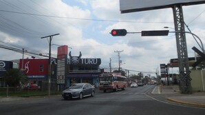 Une vue de rue avec un bâtiment portant l’inscription « PURA TORO » et un autobus.
