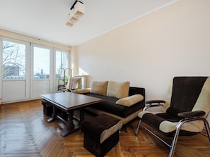 Ein modernes Wohnzimmer mit einer Couch, einem Sessel und einem Esstisch.