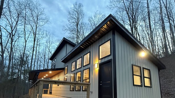 A modern house with a deck, large windows, and a door. - RRG Cabin - 2 King Suites + Ride-In Access (Stanton)