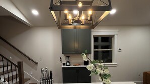 A kitchen with a central island, a hanging light fixture, and a window. - RRG Cabin - 2 King Suites + Ride-In Access (Stanton)
