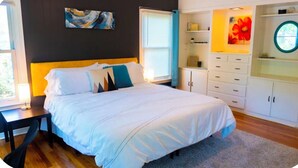 Un dormitorio con cama, mesita de noche y ventana.