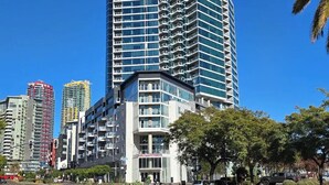 A high-rise building with a modern glass facade, multiple balconies, and a prominent 'Park 2' sign.