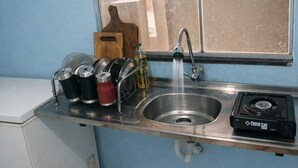 Et køkken med en rustfri stålvask, gasblus og et vindue med udsigt.