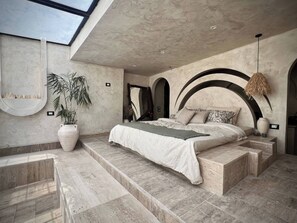 A bedroom with a large bed, a potted plant, and a skylight. - Private Oasis Roof (Giza)