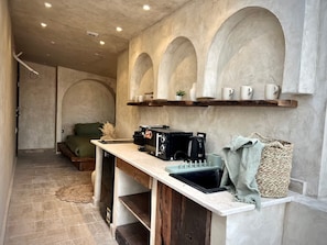 A compact kitchen with a built-in stove, a coffee machine, and a shelf with cups. - Private Oasis Roof (Giza)