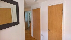A hallway with wooden doors and a mirror on the left wall. - 2-Bed 2-Bath Sea-View Balcony Apt inc Sun Terrace minutes to Sea, Station, Shops (Brighton and Hove)