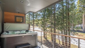 A spa area with a hot tub, a small bench, and a view of a forested area. - New Luxury 4BR /3BA Obsidian Reserve #88 – Private Hot Tub & Sauna, 2-Car Garage, gr8 Views! (Mammoth Lakes)