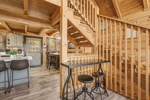 Ein Holzinterieur mit Bar, Hockern und einer Treppe.